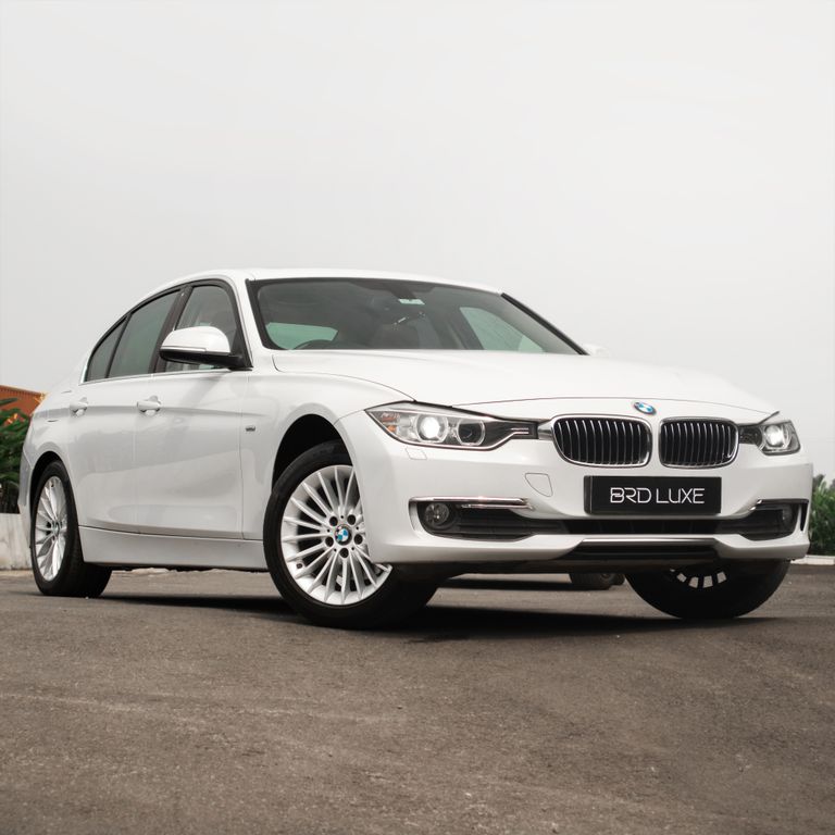 Luxury white BMW sedan with shiny rims and dynamic angle, perfect for automobile enthusiasts.